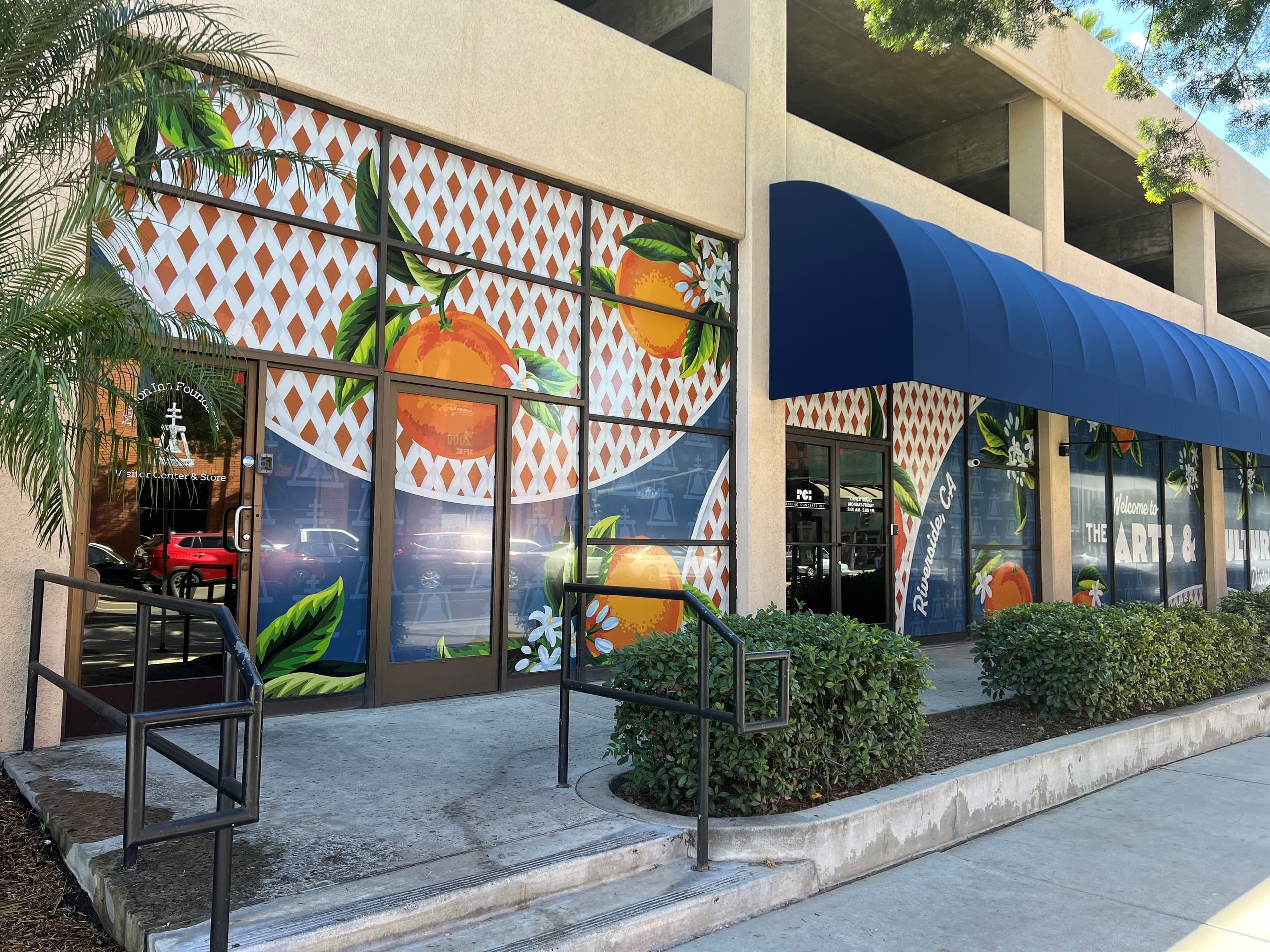 Colorful storefront mural and blue awning outside downtown Mission Inn area