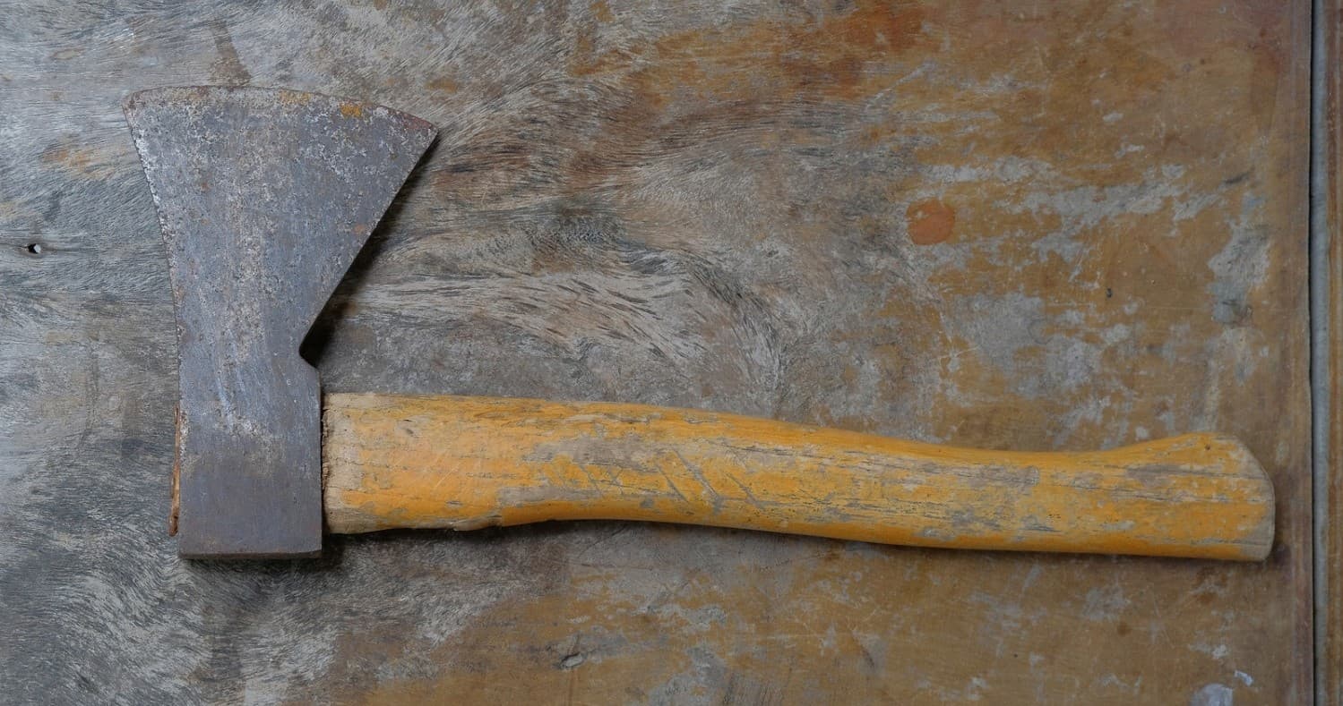 Single hatchet on wooden surface, close-up rustic tool detail