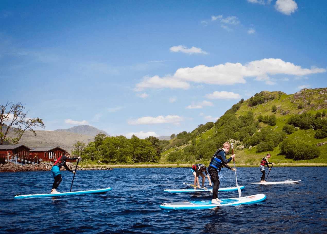 Stand up paddleboarders touring Loch Lomond blue water