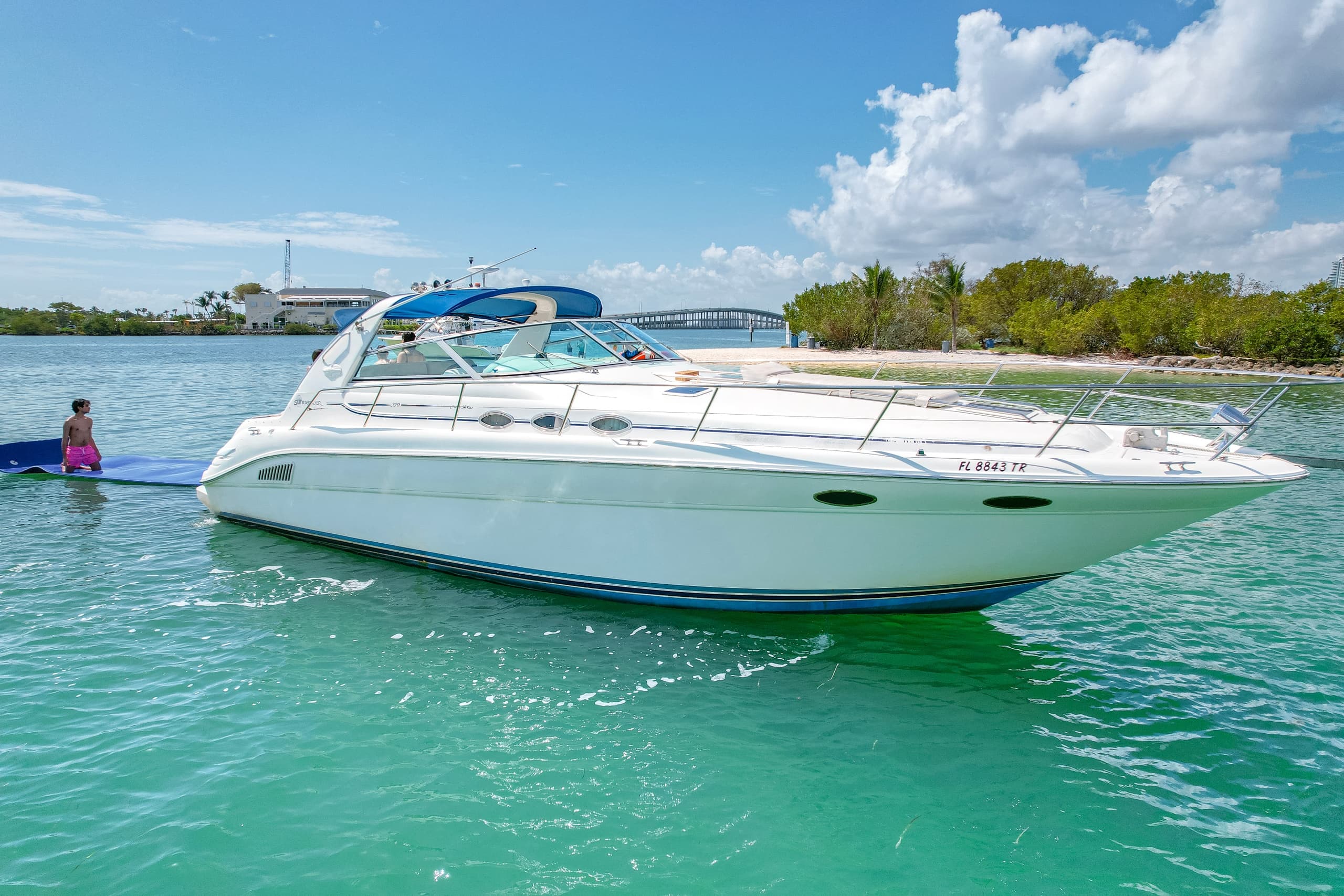 White yacht cruising calm bay with distant city skyline view