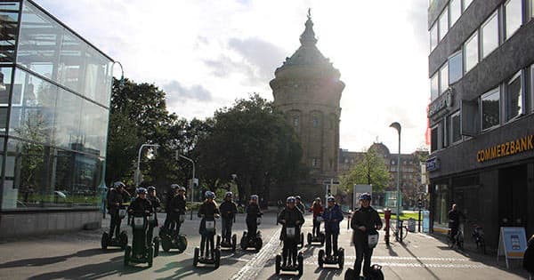 Group Segway tour rolling through city street past landmark