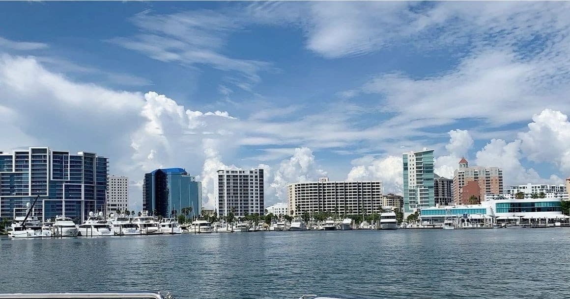 Waterfront city skyline and marina with boats docked under blue sky