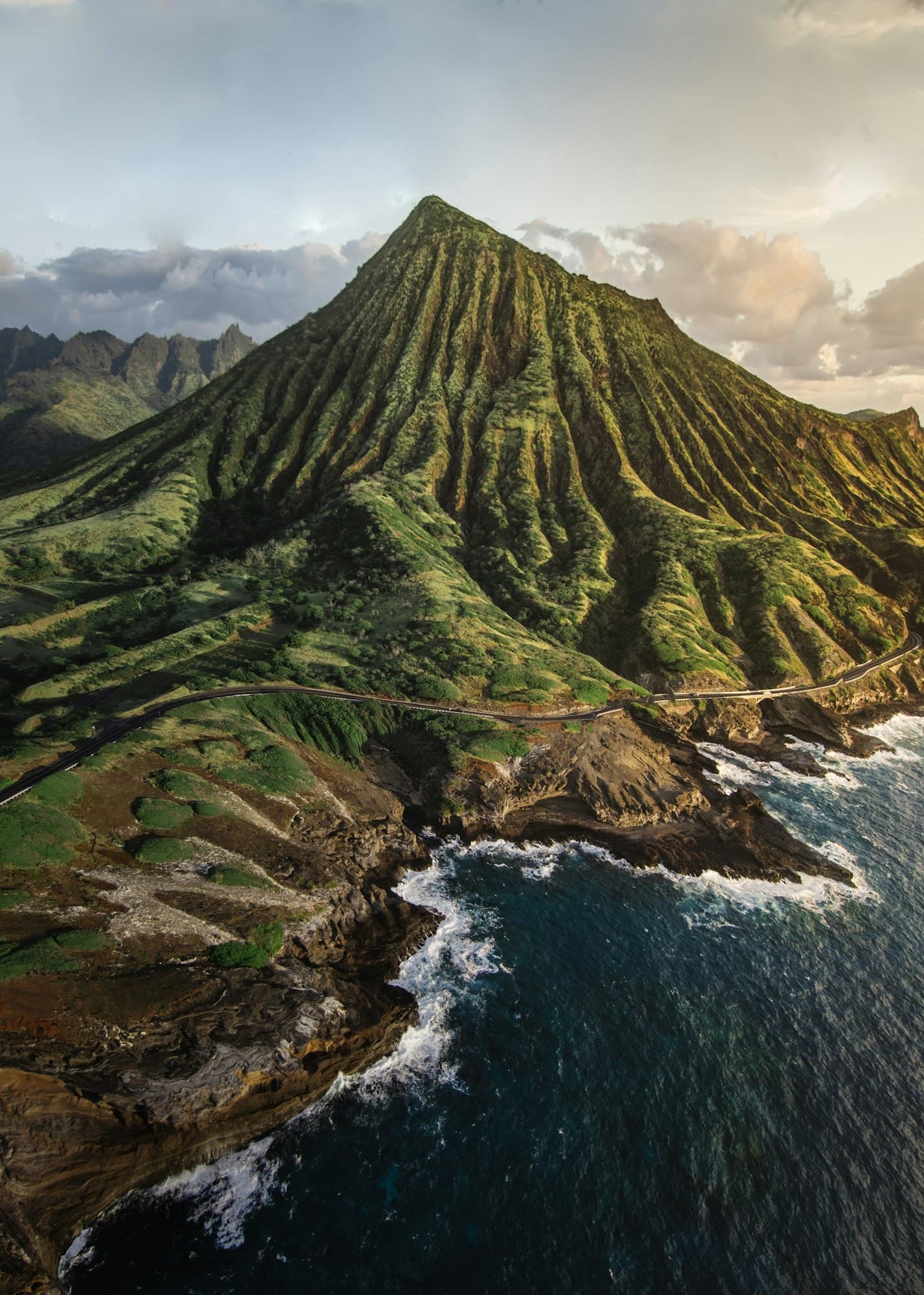 Aerial volcanic ridge and coastal cliffs above Pacific shoreline