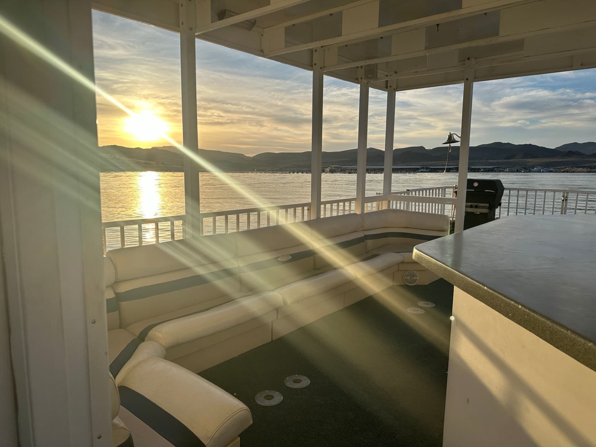 Covered boat deck at sunset overlooking lake, golden light