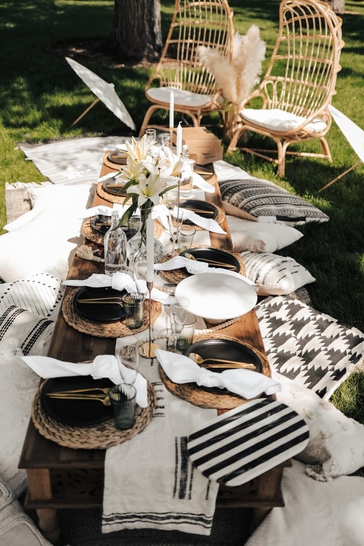 Boho outdoor picnic table setting on grass for intimate dining