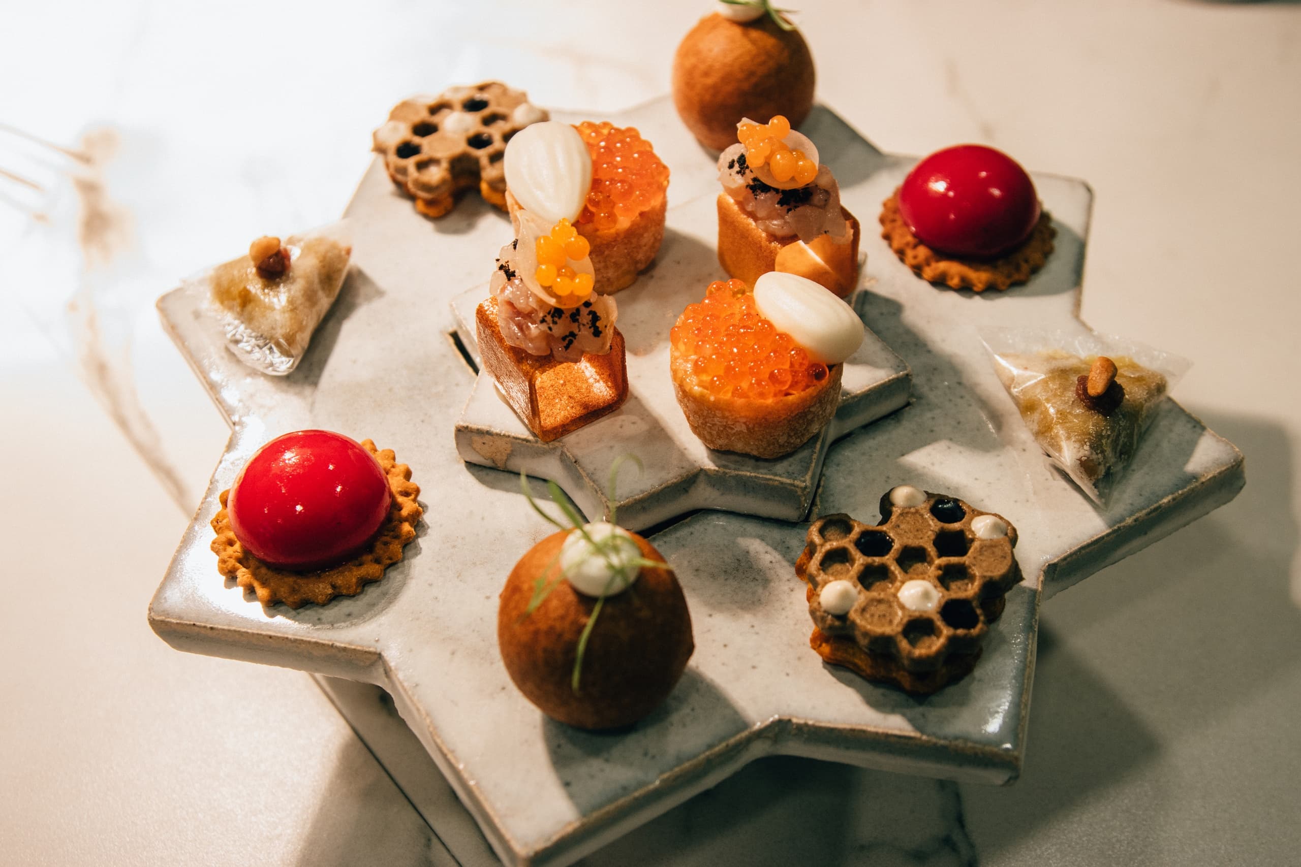 Assorted bite-sized desserts on decorative platter at indoor event