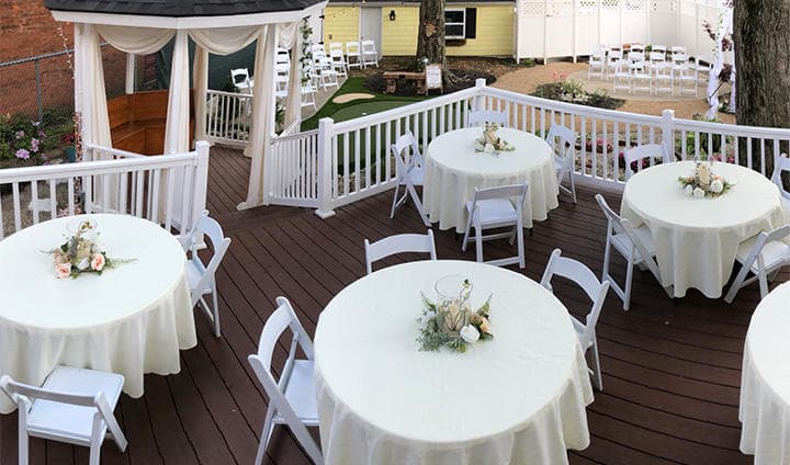 Outdoor deck dining with round tables set for reception event
