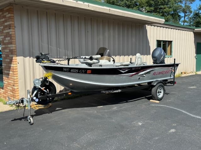 Small aluminum fishing boat on trailer outside rental shop