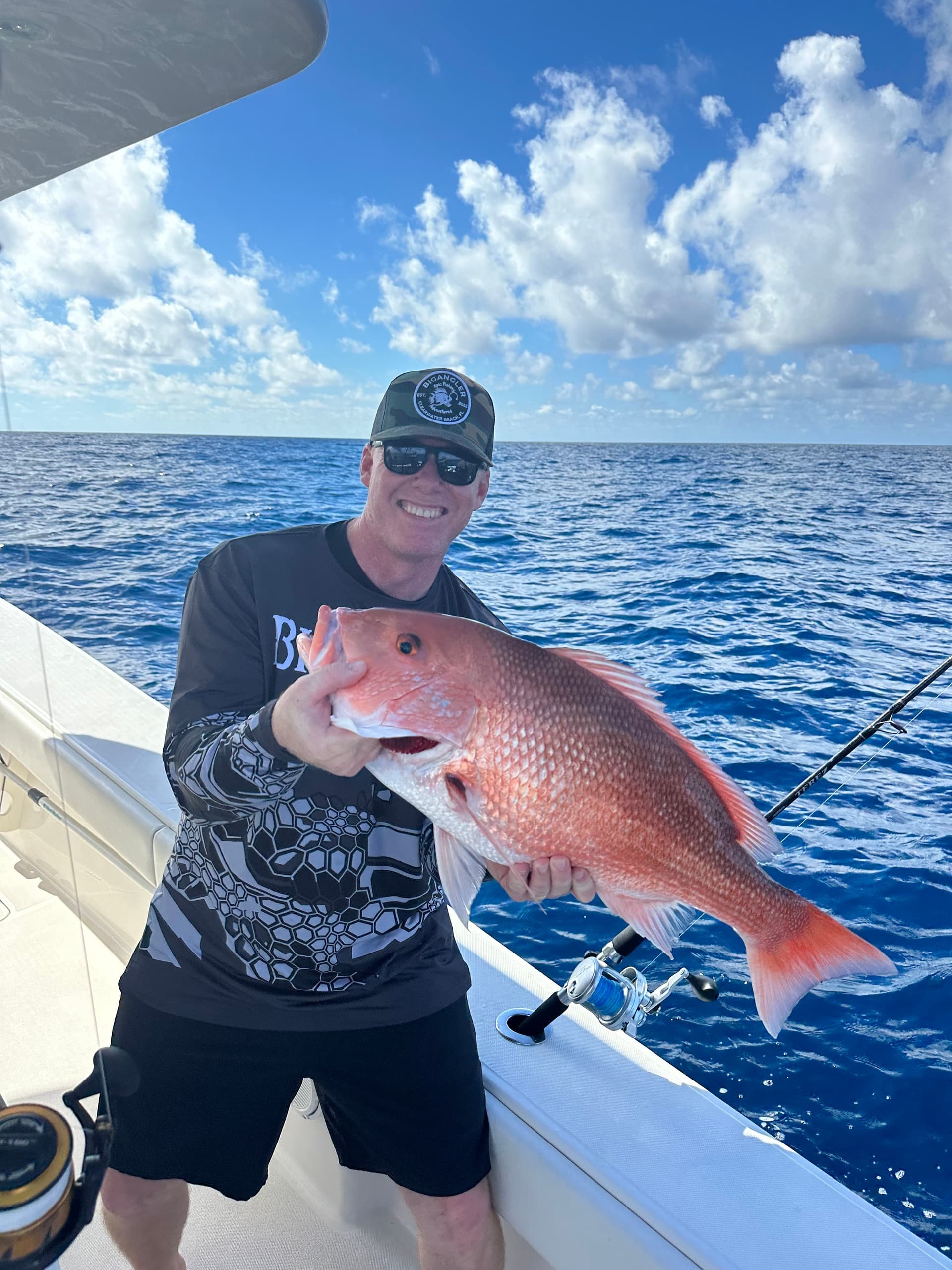 Angler holding large red snapper on offshore deep-sea fishing trip