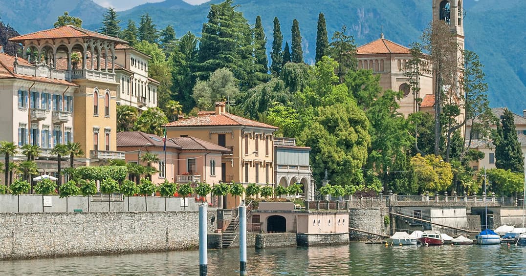 Lakeside historic villas and waterfront promenade with mountain views