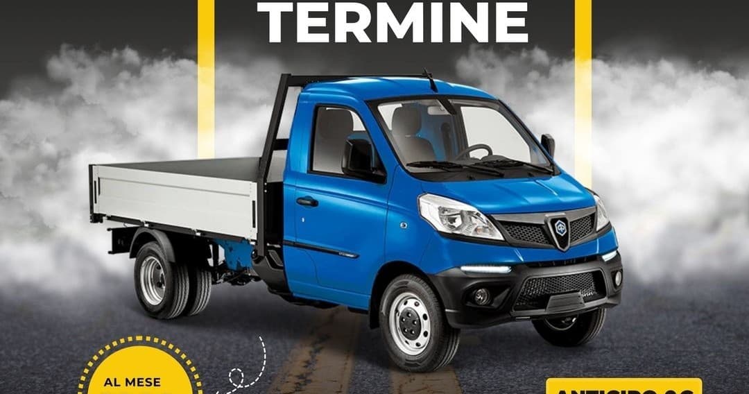 Blue utility truck driving on open highway under dramatic sky