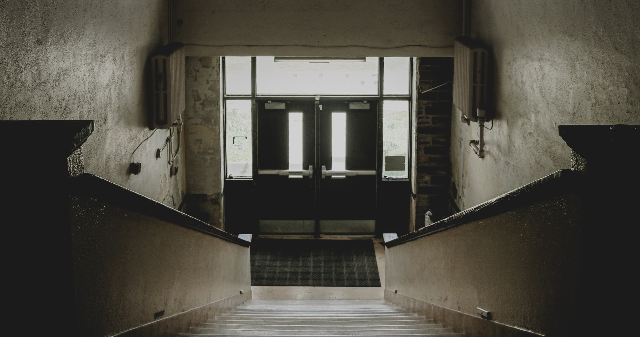 Abandoned stairwell entrance of haunted house interior, descending