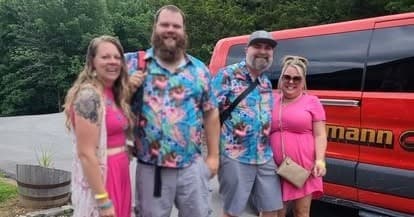Small group standing by branded tour van after trolley ride