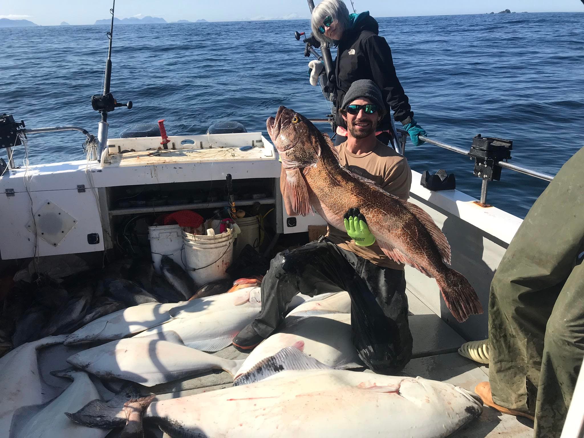 Group of anglers posing with big halibut on dock in Alaska
