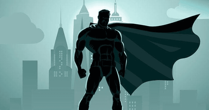 Superhero silhouette standing on rooftop overlooking urban skyline