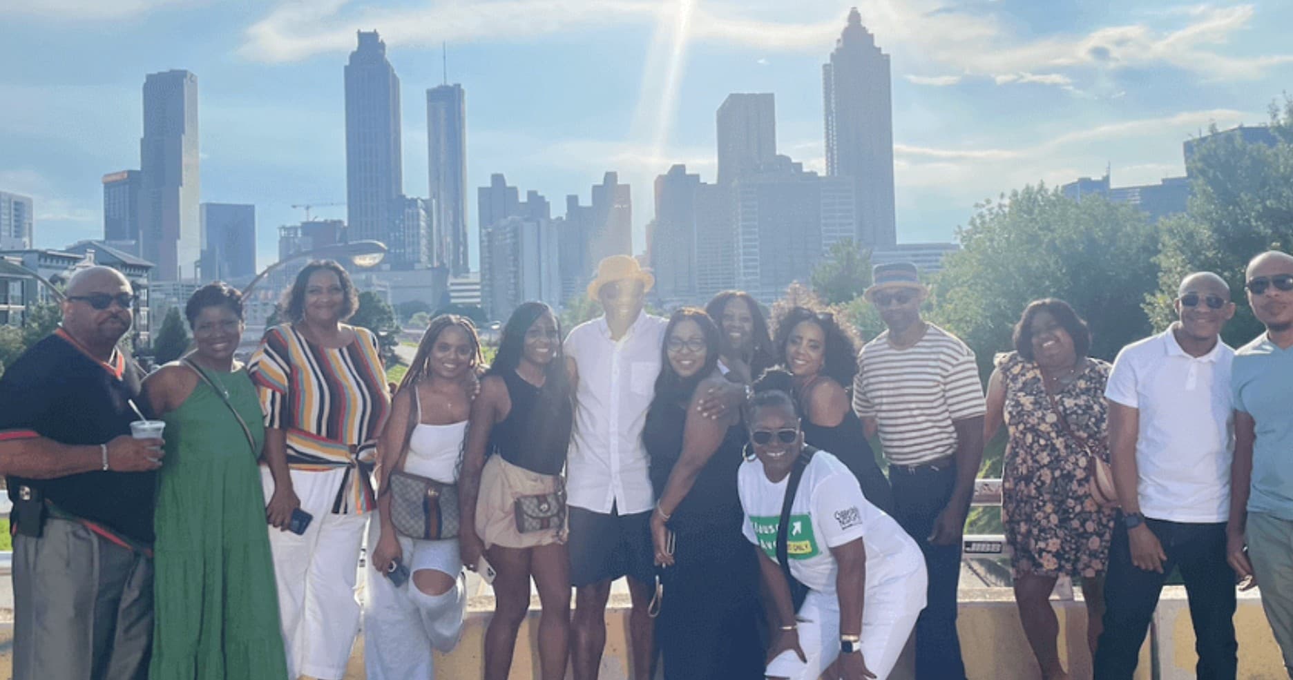 Group tour posing with Atlanta skyline views at sunset