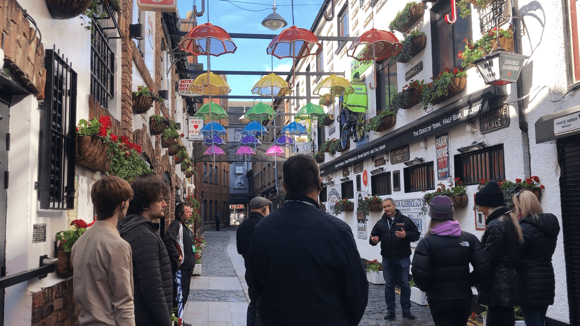 Colorful pedestrian alley walking tour under umbrella canopy