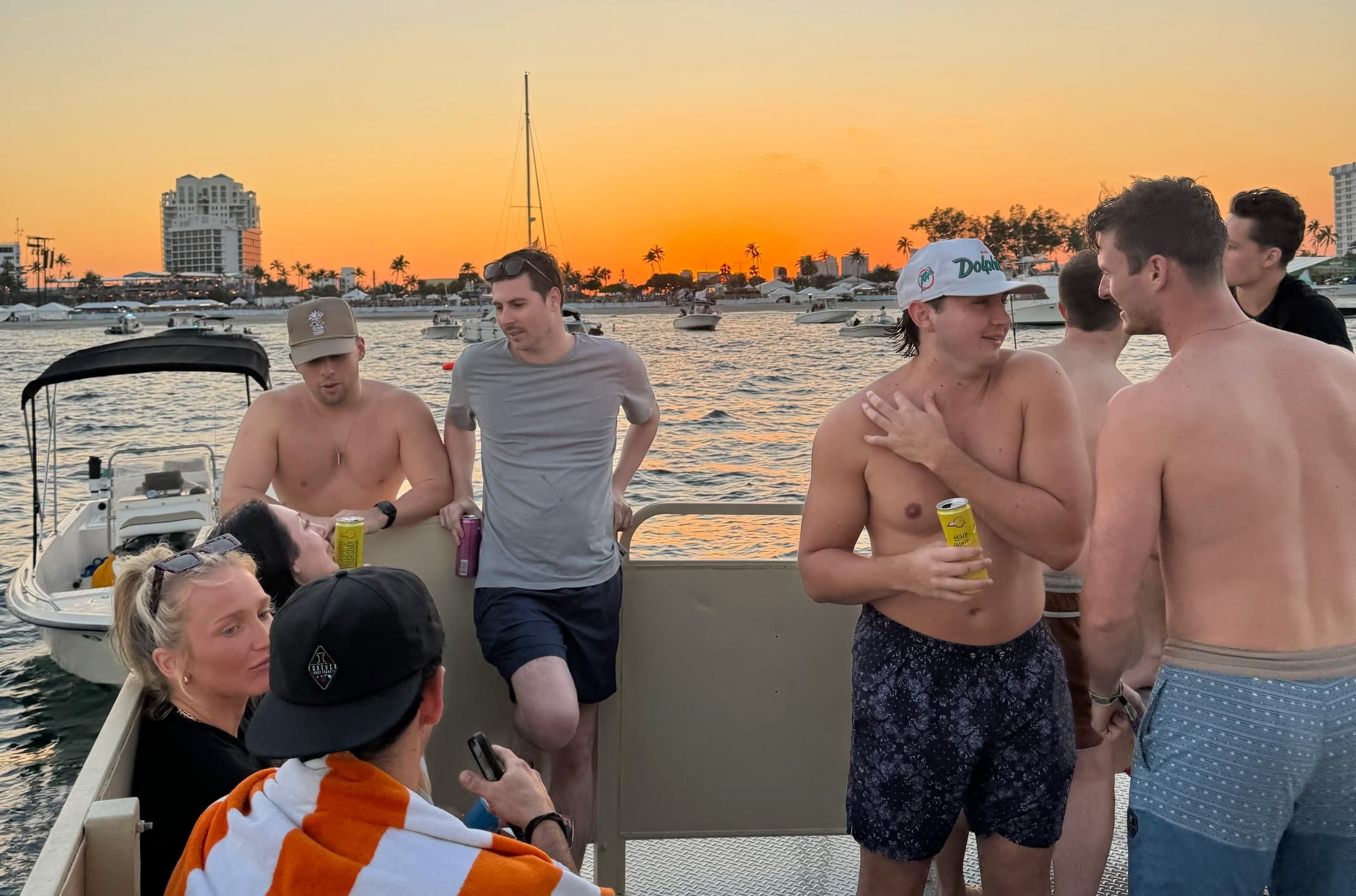 Friends socializing on charter boat at sunset in harbor