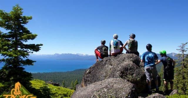 Group of mountain bikers at Tahoe overlook admiring lake vista