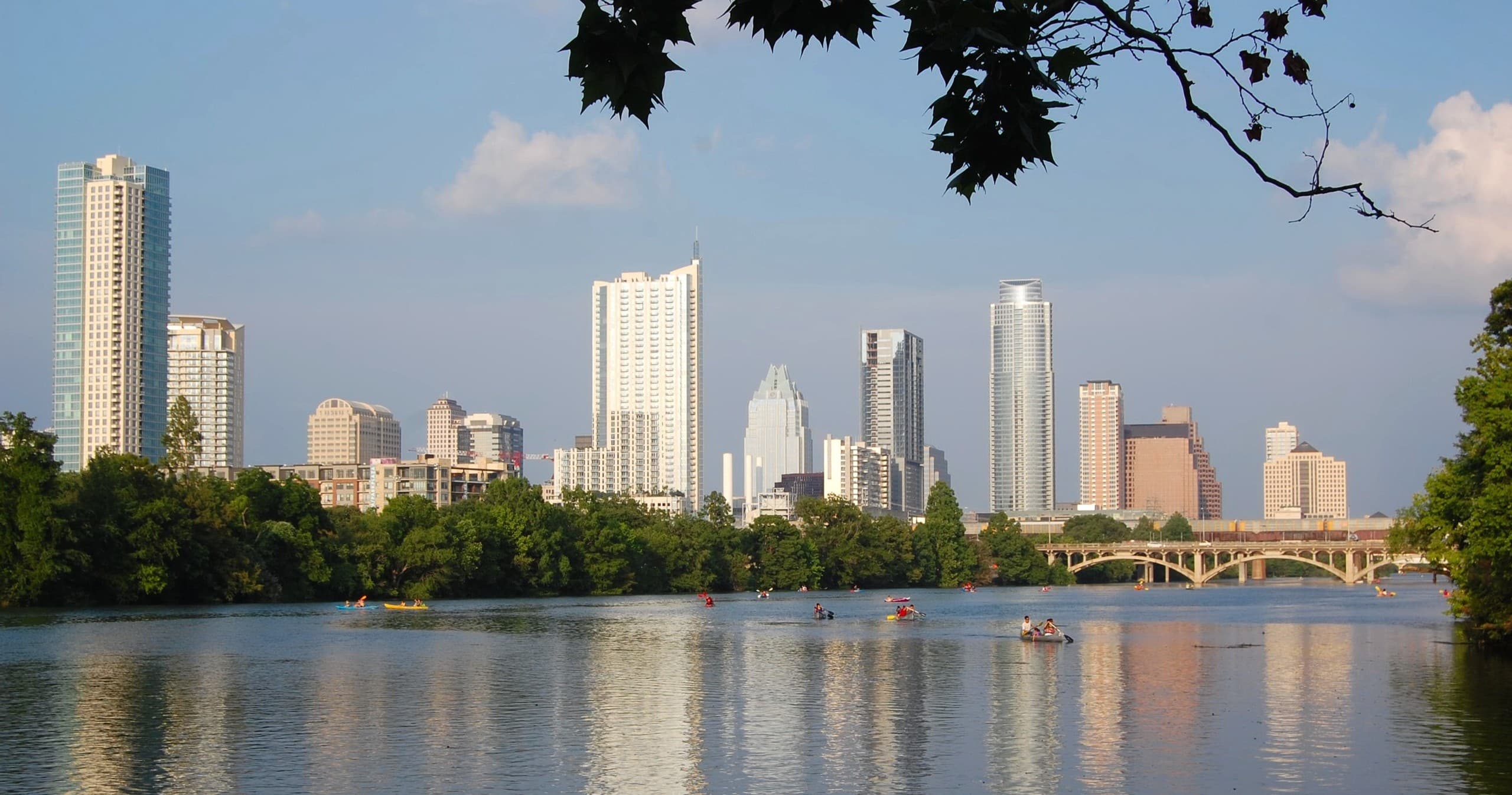 Austin skyline across Lady Bird Lake with kayakers boating