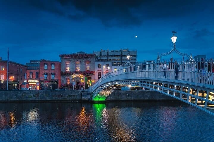 Twilight view of historic pedestrian bridge over urban river