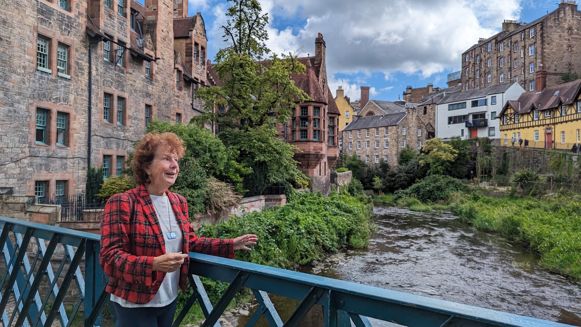 Person enjoying riverside bridge view in historic European town