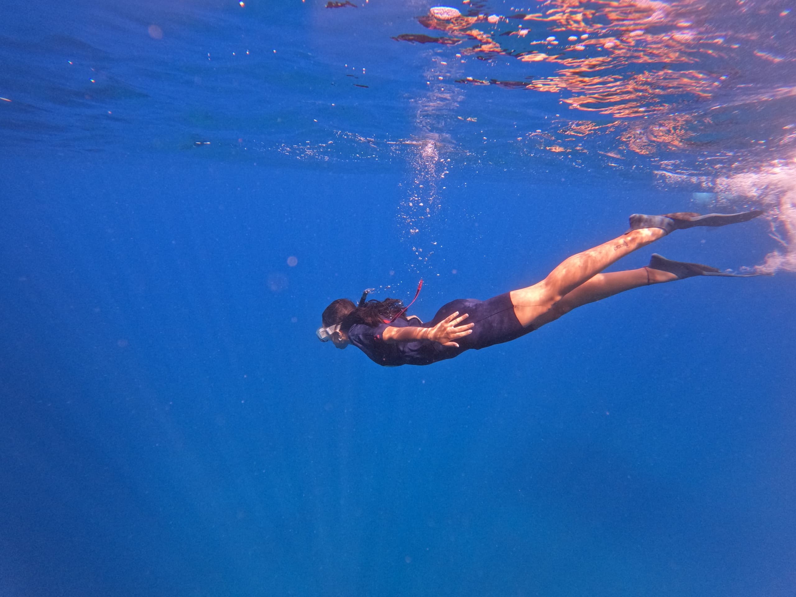 Snorkeler exploring clear blue ocean water near coastal reef