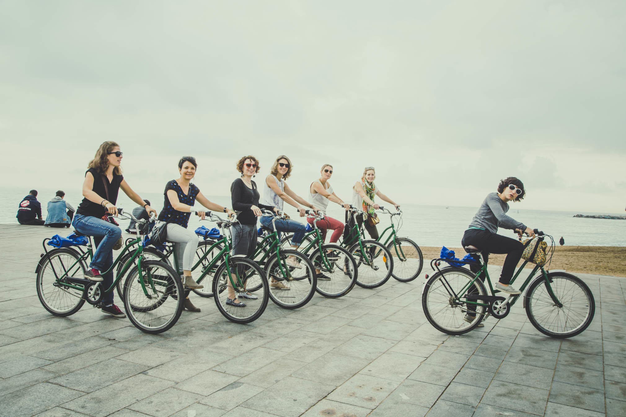 Group bicycle tour cycling along coastal promenade at sunrise