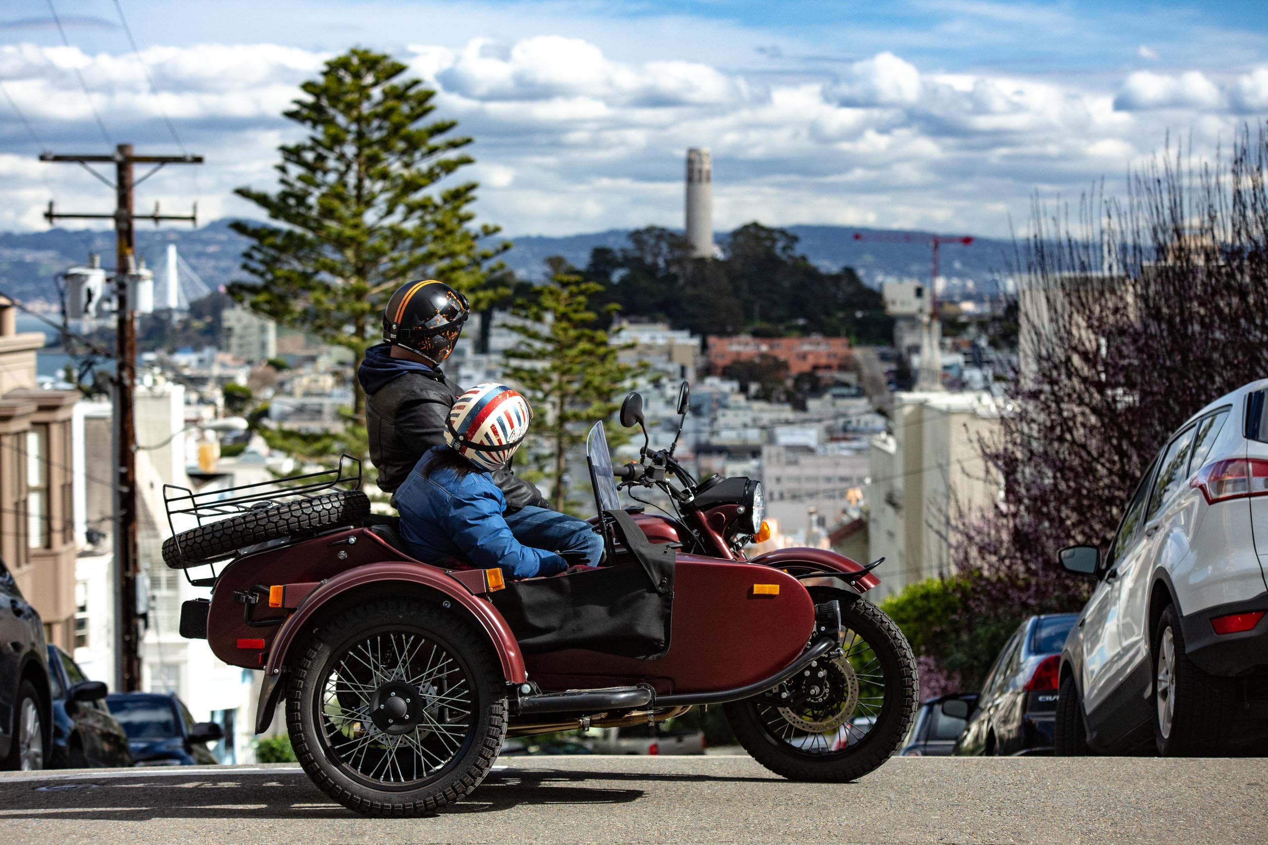 Sidecar motorcycle parked on hill with city skyline and Coit Tower