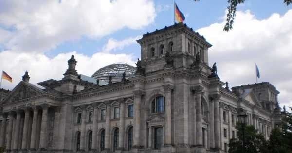 Sightseeing at Reichstag building with German flags in Berlin