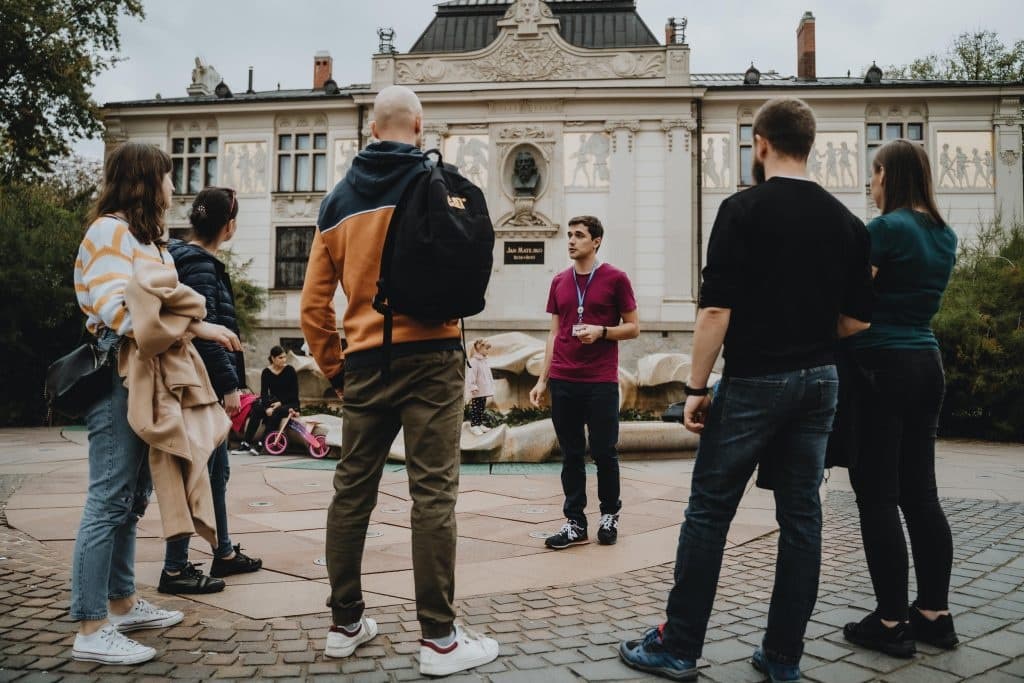 Group walking tour in Krakow square with guide and participants