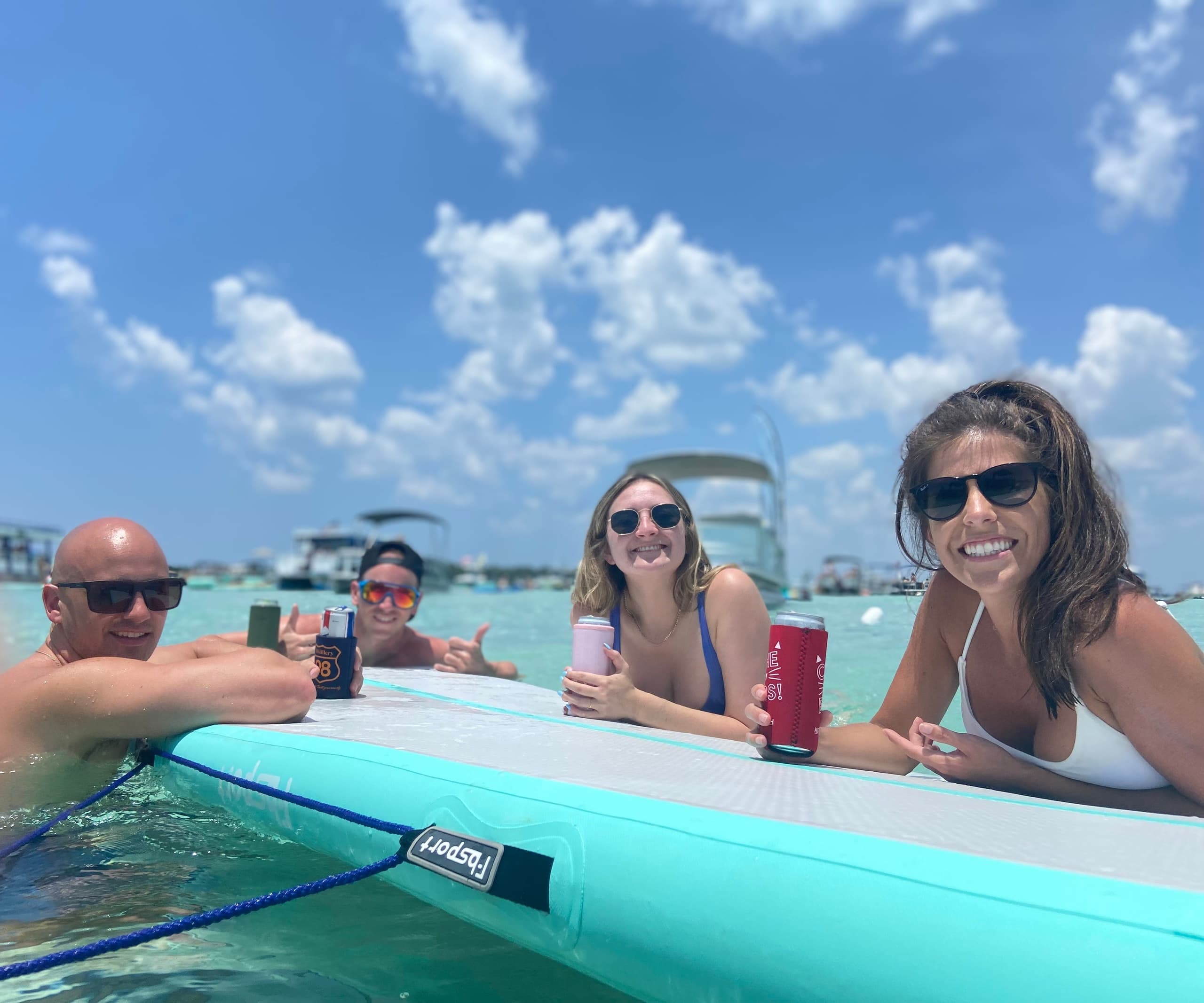 Friends lounging on paddleboard in crystal shallow Florida waters