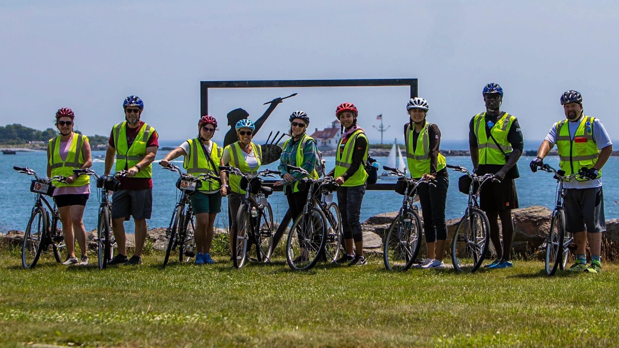 Cyclists on coastal bluff with wide ocean vista bike tour