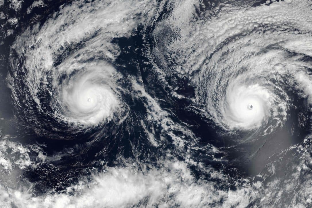 Dual hurricanes spiraling over open ocean in satellite view