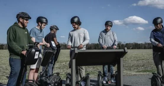 Guided Segway tour group riding across open Virginia fields
