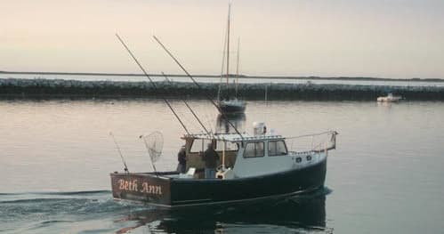 Charter fishing boat cruising Provincetown waters at sunrise