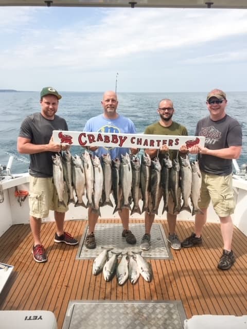 Charter anglers displaying fresh catch on boat deck in Gulf offshore