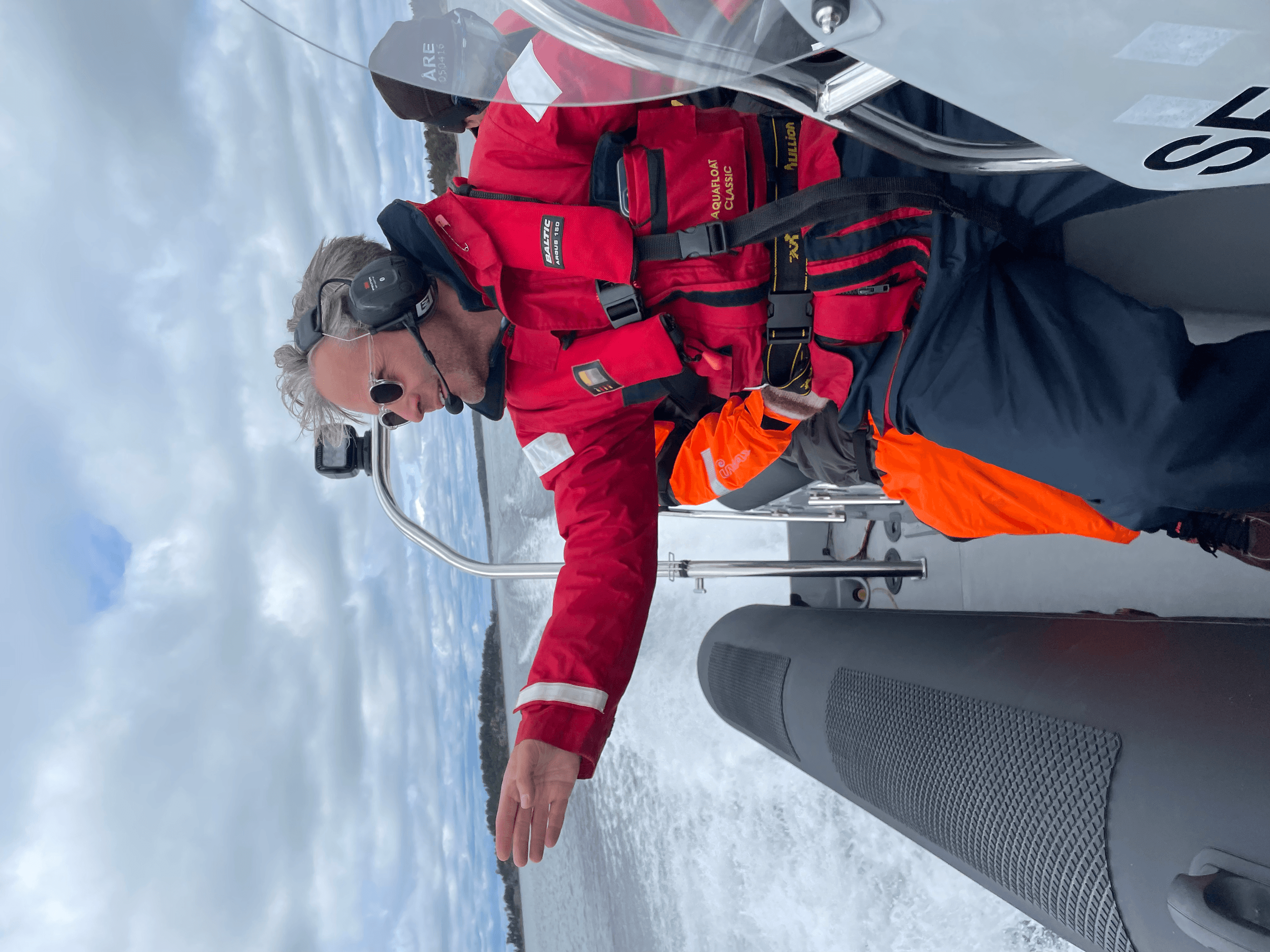 Crewman steering rigid inflatable boat during choppy sea outing