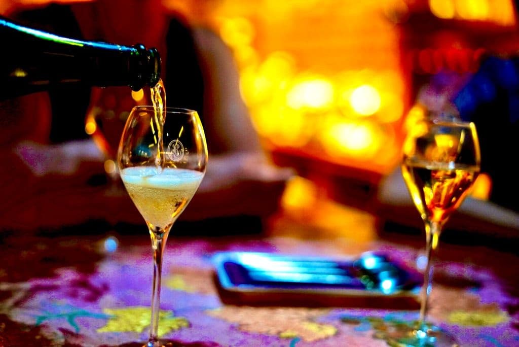 Wine being poured into glasses at colorful indoor tasting bar
