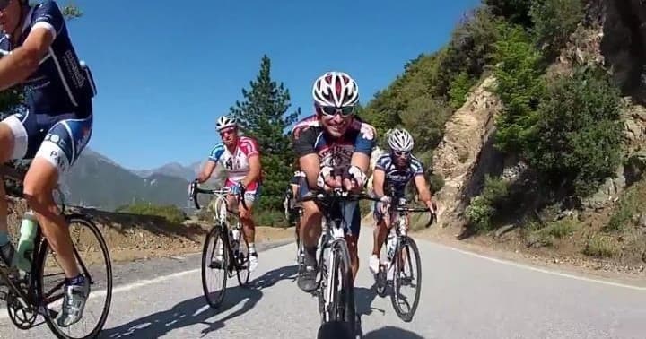 Group road cycling on mountain pass showcasing scenic alpine route