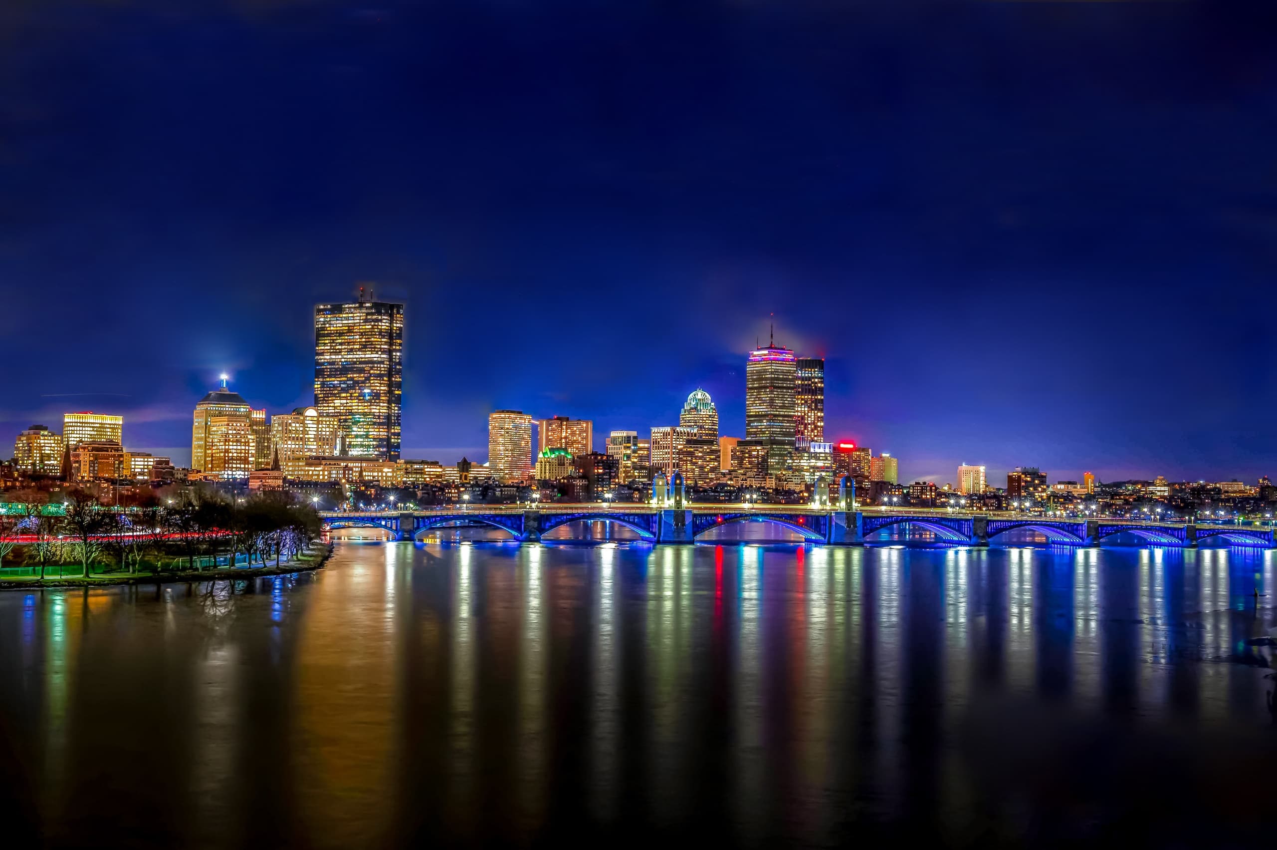 City skyline reflected on river at night, urban photography