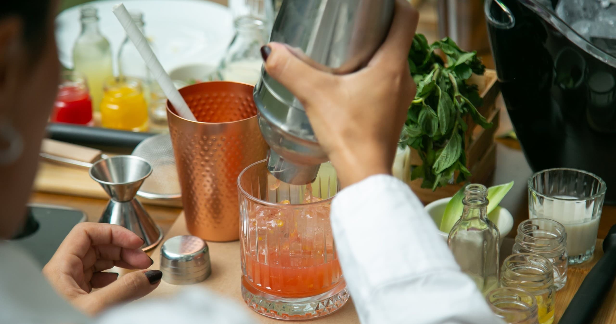 Bartender shaking cocktails at revel cafe and bar counter indoors