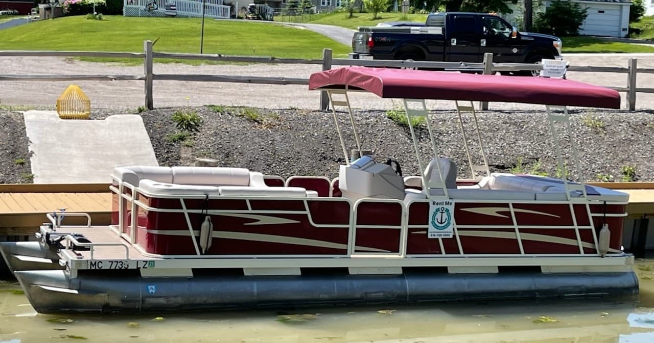 Pontoon boat docked at lakeside marina ready for leisure cruising