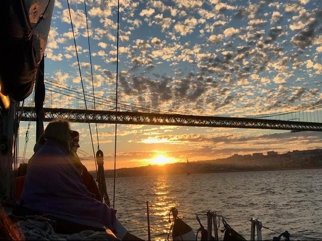 Sunset sail with crew watching dramatic cloud-filled sky