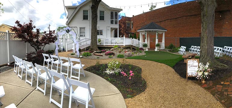 Outdoor wedding ceremony seating along landscaped garden path