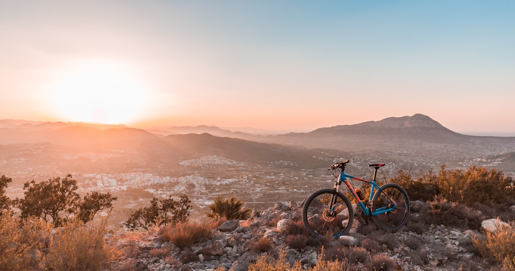 Mountain trail bike at sunset, panoramic ridge cycling scene