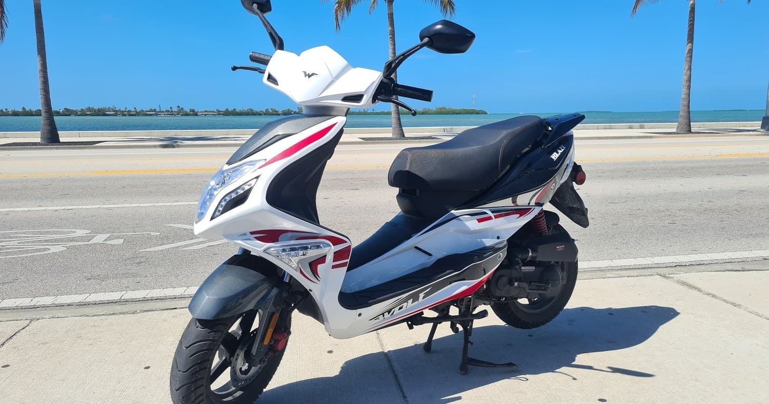 White moped parked on oceanfront road in Key West for scenic rides