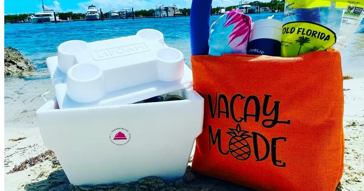 Beach picnic kit and cooler on sandy shore with ocean