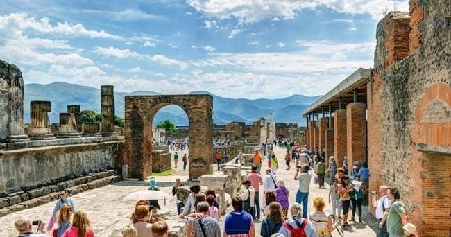 Guided Pompeii ruins walk with crowds under blue sky