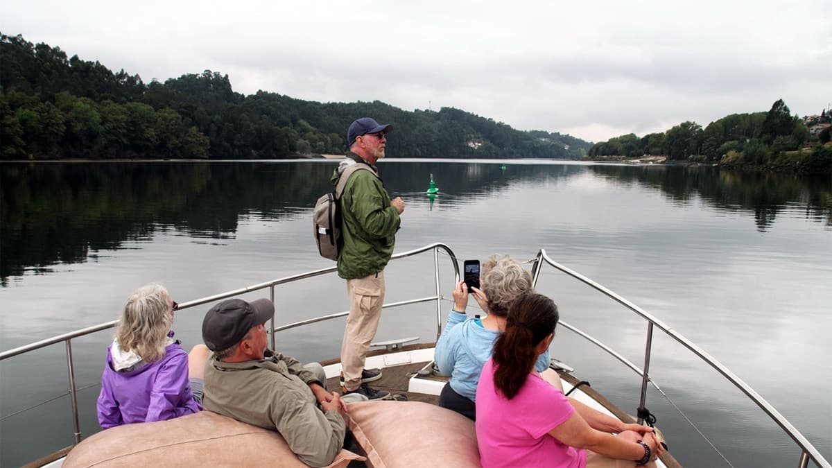 Small group on boat wildlife tour along calm river